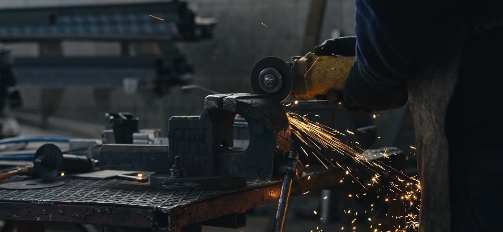 Fabricator cutting steel on the workshop floor