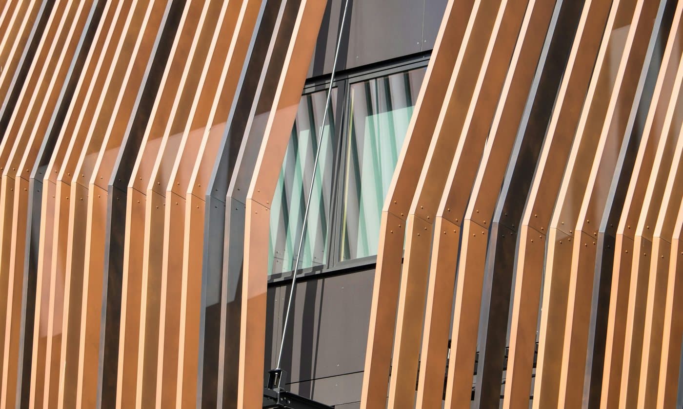 Angled timber fins shading a glazed terminal facade